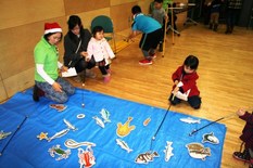 「手づくりマーケットinゆう」のイベントを写した様子。子どもが魚のイラストを釣り竿で釣るゲームをしている。
